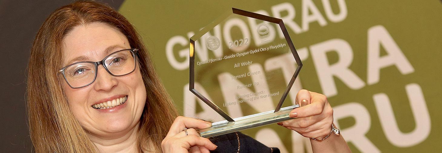 Winner Tammi Owen holding her award in front of the Lantra Cymru Awards 2022 sign