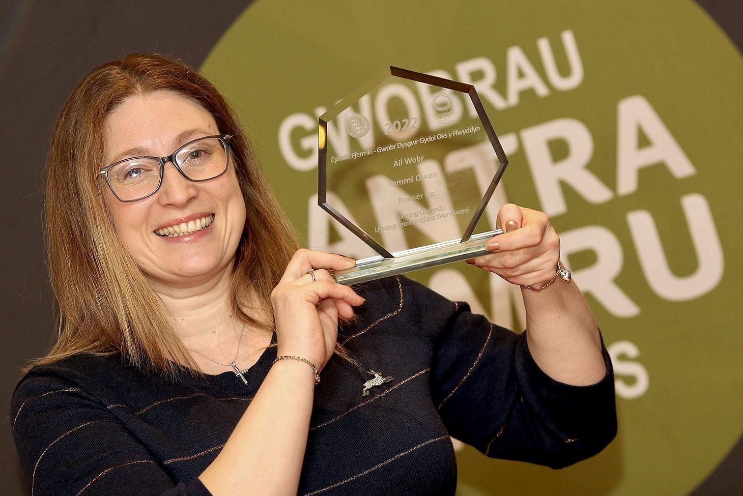 Winner Tammi Owen holding her award in front of the Lantra Cymru Awards 2022 sign